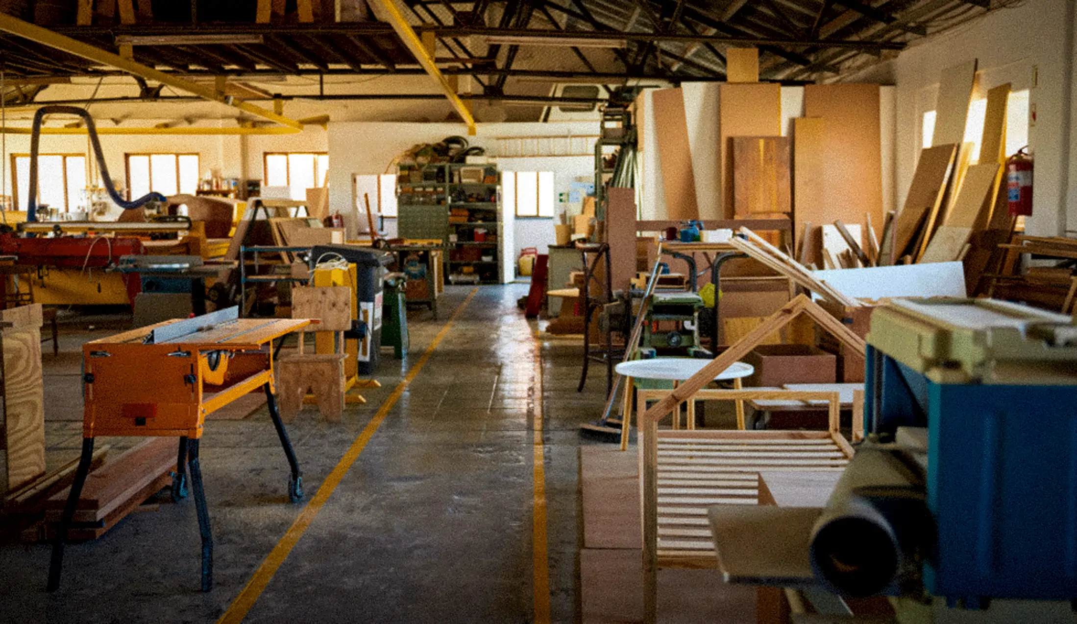 a large commercial wood workshop with various work benches, tool and wood